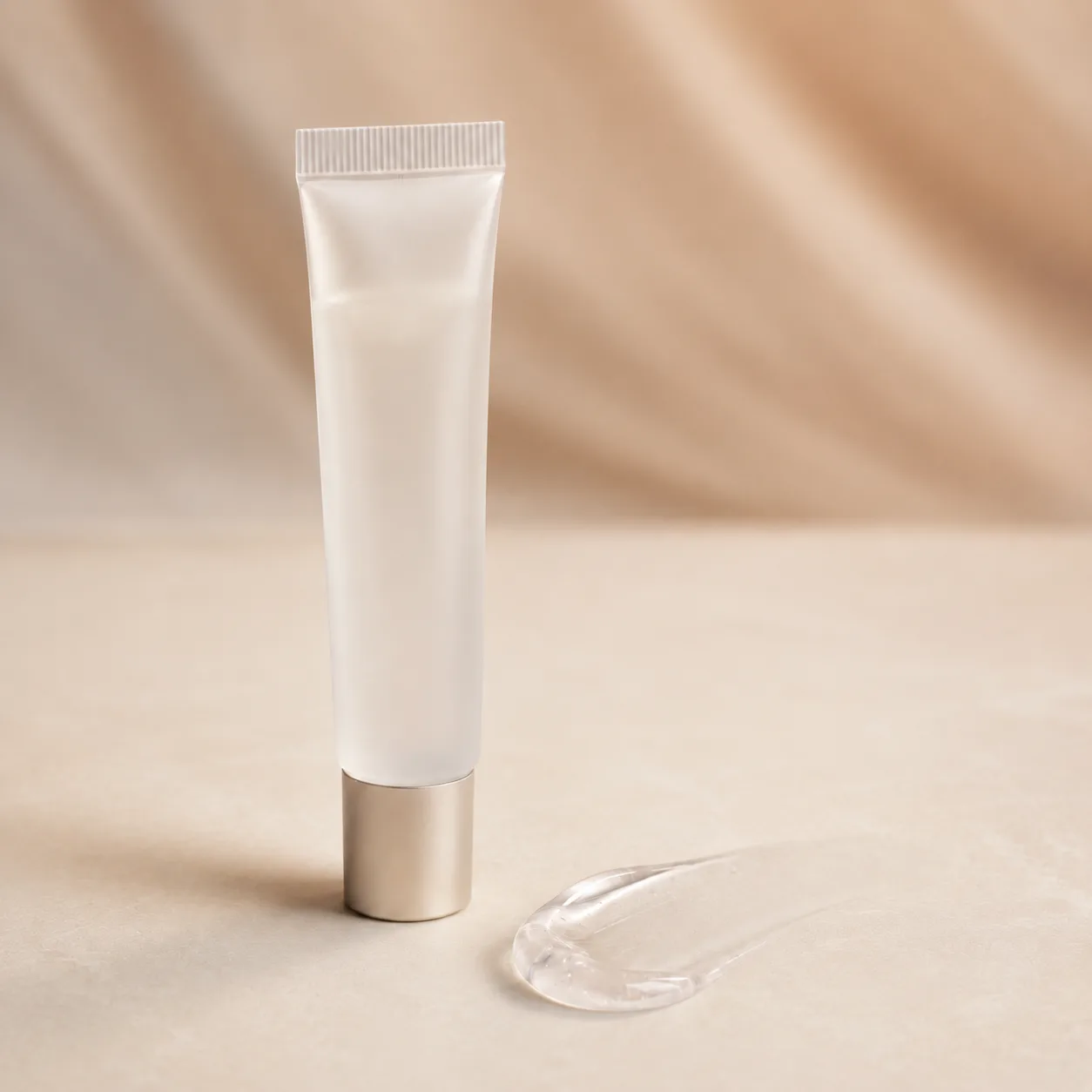 An unbranded tube of primer standing beside a clear swatch of the gel